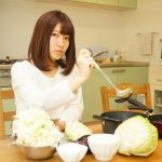 Young woman using a smartphone while cooking